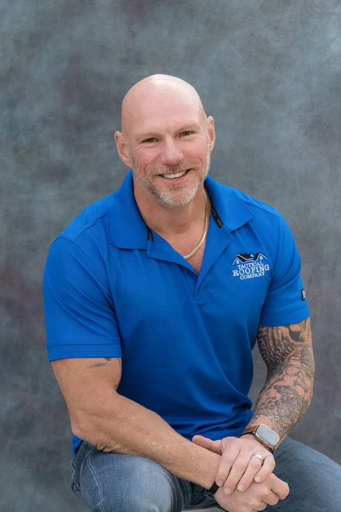 Professional photo of a man in blue tactical roofing shirt- Adam Boudreaux (President and Owner)