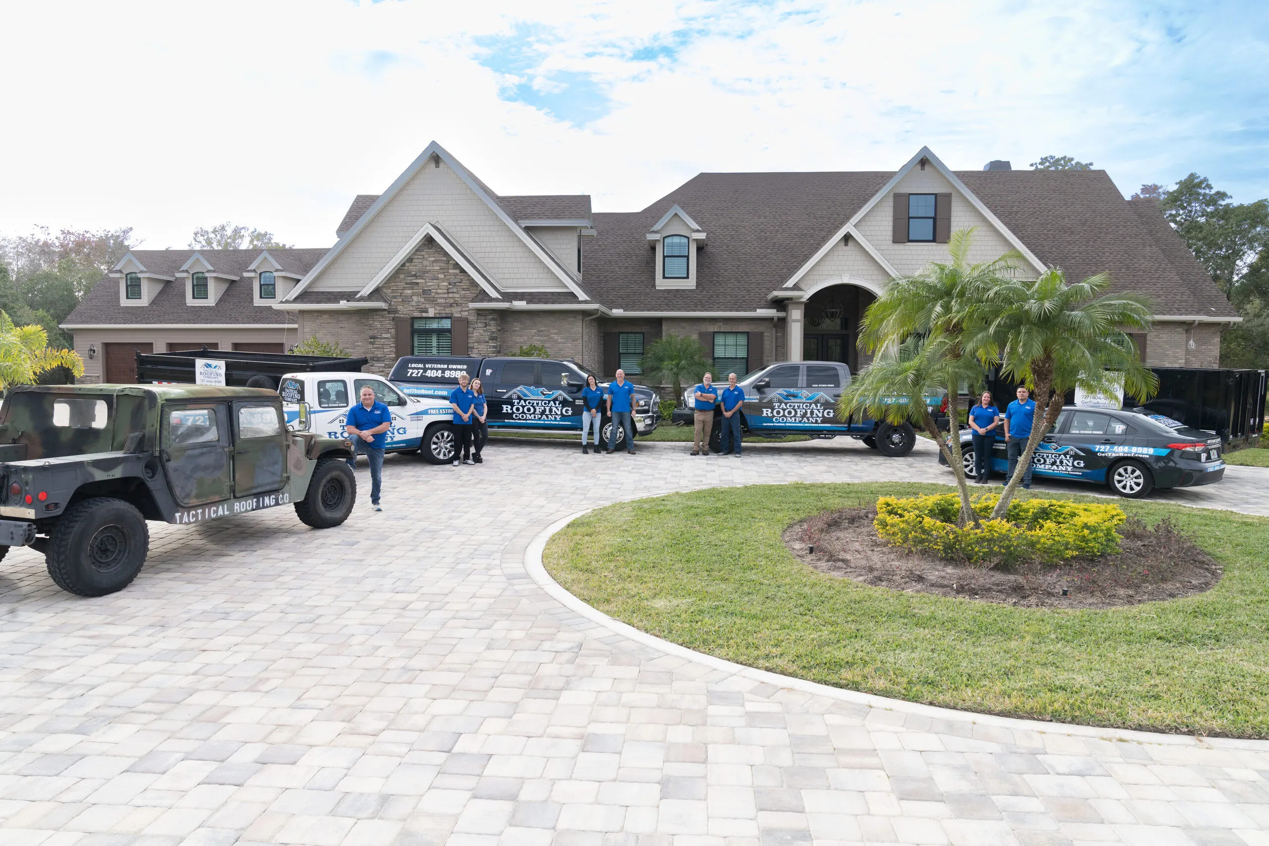 The Tactical Roofing Company crew with their fleet outside a completed Tampa Bay home